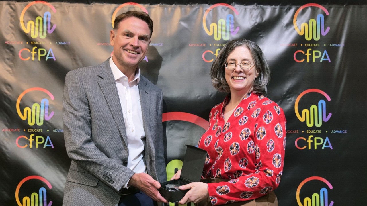 Paul receiving the CfPA 'Pay it Forward' Award 2025 from Jenny Kassan